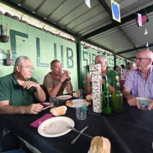 Participantes reunidos alrededor de una mesa durante una comida vinculada a la cultura sidrera