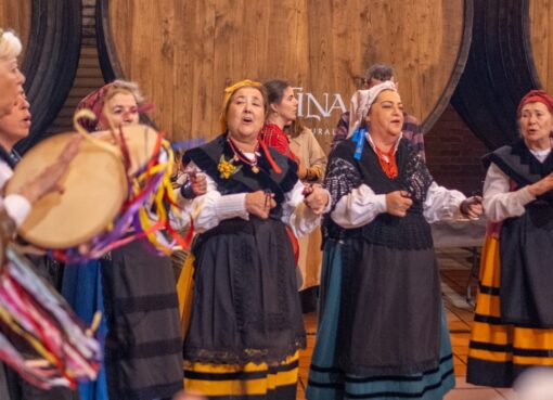 Un grupu de pandereteres actúa delantre de los toneles de madera de Sidra Cortina