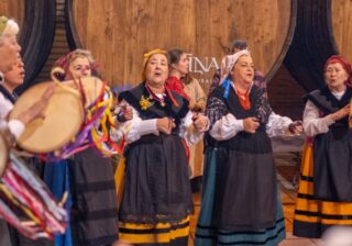 Un grupo de pandereteras actúa ante los toneles de madera de Sidra Cortina