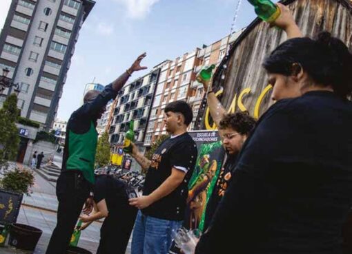 Alumnáu de la escuela de Tierra Astur practicando cómo echar sidre en Gascona