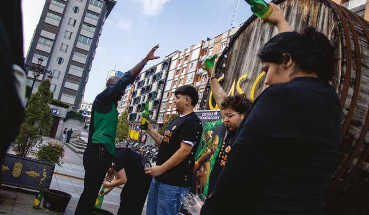 Alumnáu de la escuela de Tierra Astur practicando cómo echar sidre en Gascona
