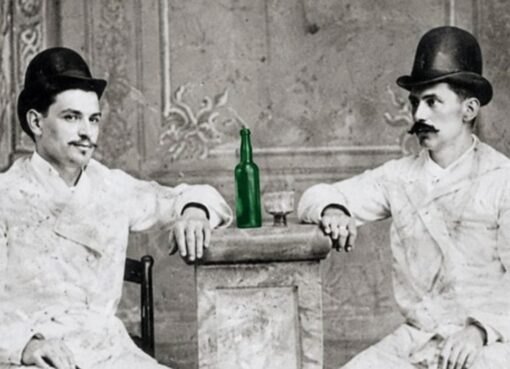 Dos emigrantes asturianos en Cuba, en 1885, con una botella de sidra y un vaso.