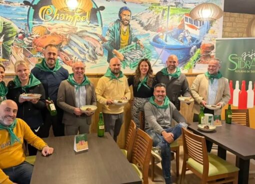 Participants wearing green scarves at the opening of Xixón de Sidra 2026 at Sidrería Champel.